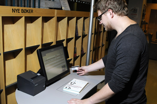 Masterstudent Espen Bolghaug testra NHH-bibliotekets utlånsautomat (Foto: Hallvard Lyssand)